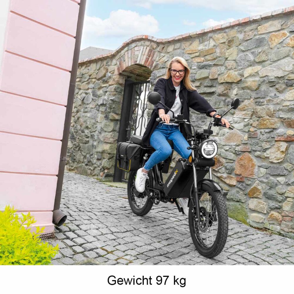Frau auf Mopedix Electrix 45er eRoller eMoped in einem Altstadt-Gässchen